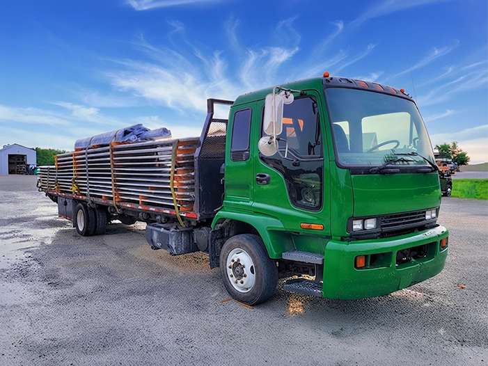 Flatbed truck loaded with the framing and panels for a steel building