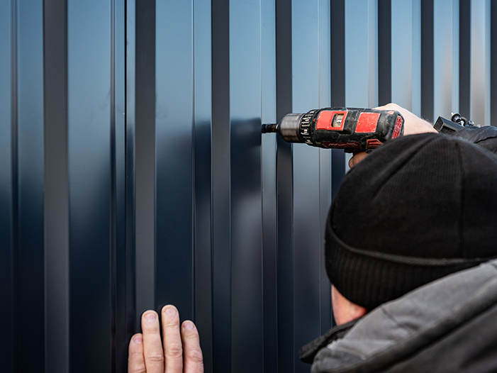 Wall panel being fastened to the frame of a steel home shell