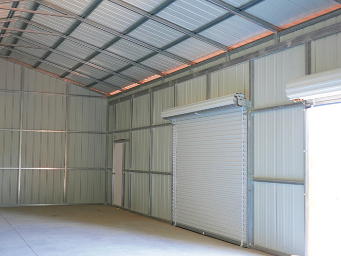 Large three-car metal garage installed on a concrete slab