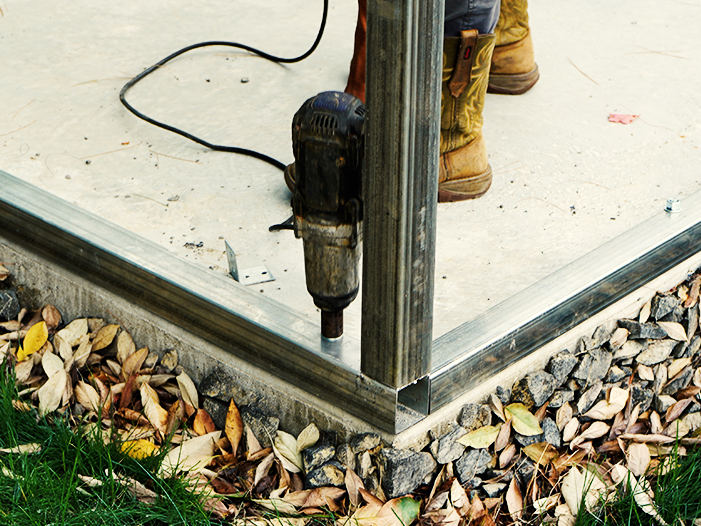 Two-car metal garage installed on a concrete pad with two roll-up doors